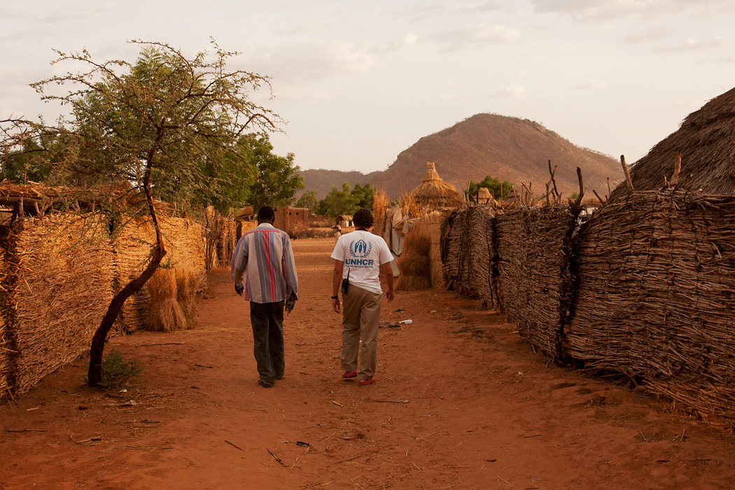 A UNHCR-worker and his local partner walk through a refugee camp in Goz Beïda, Chad.