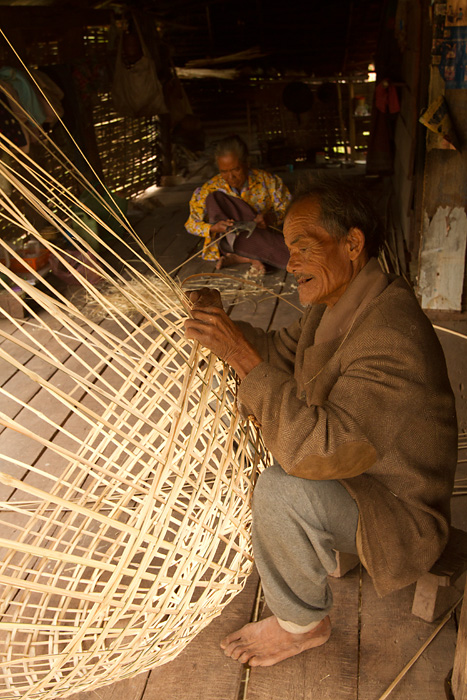 An old couple weaves bamboo baskets in their home 