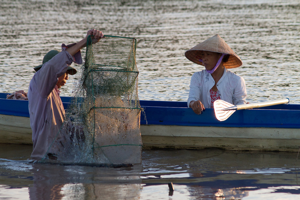 A couple retrieve their fish traps in the Cai Ngay river in the early morning.