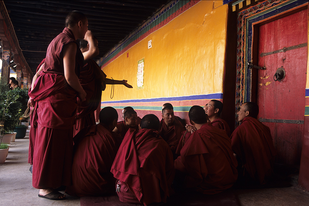 Older monks teach the younger ones in the courtyard.