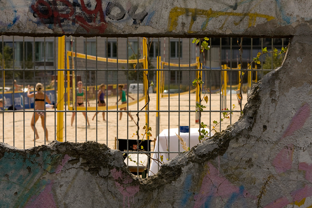 Beach volleyball fields behind one of the few remaining sections of the Berlin Wall