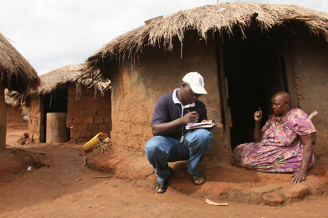 UN Volunteer Gerald Janani Loum speaks to an elderly woman at an IDP camp in northern Uganda