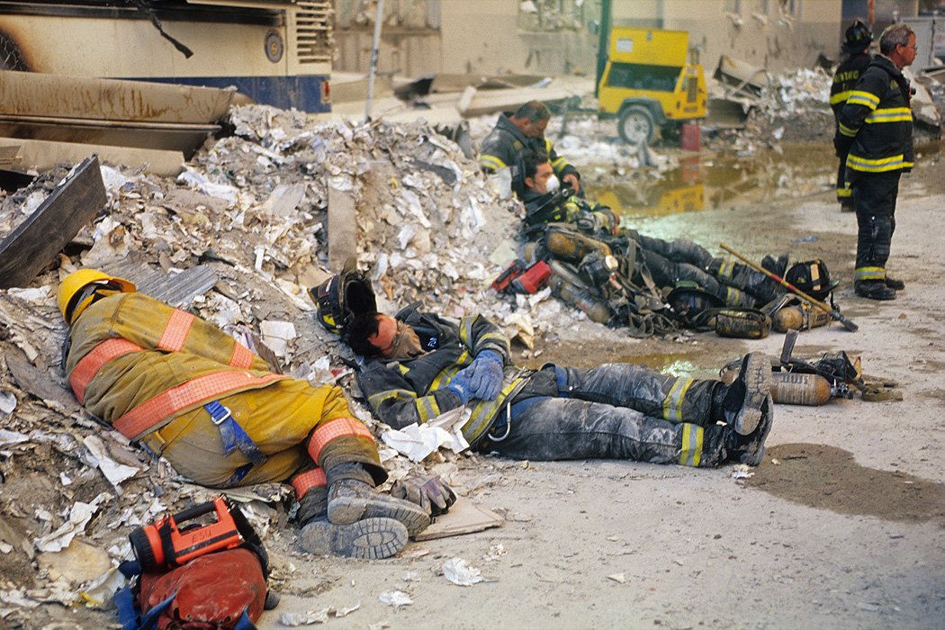 Exhausted firefighters sleep in the debris across the street from the World Trade Center site