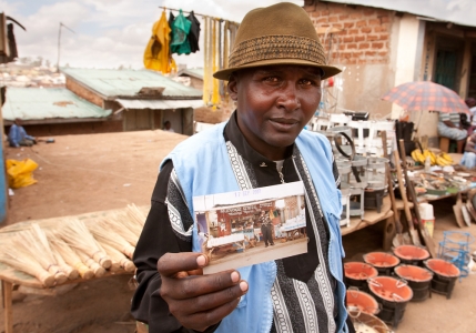 A man in Mathare Slum in Nairobi, Kenya shows a picture of his store, which was destroyed during ethnic violence.